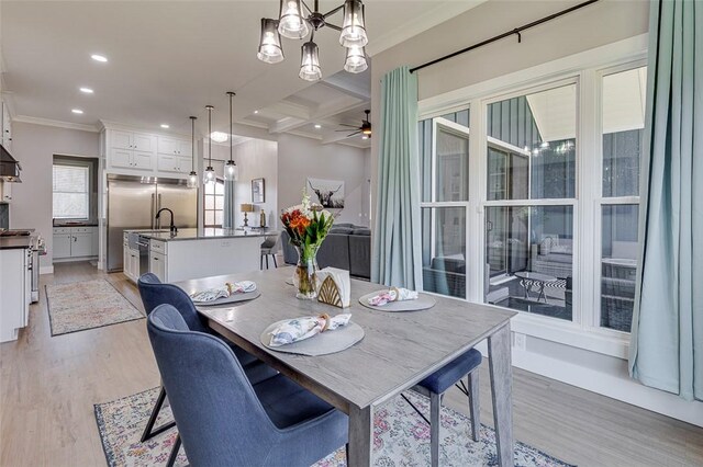 dining room featuring recessed lighting, light wood-style flooring, ornamental molding, coffered ceiling, and ceiling fan with notable chandelier