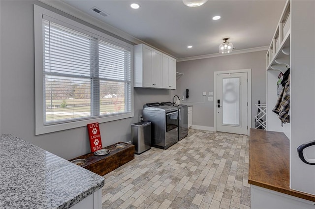 clothes washing area with crown molding, recessed lighting, cabinet space, visible vents, and washer and dryer