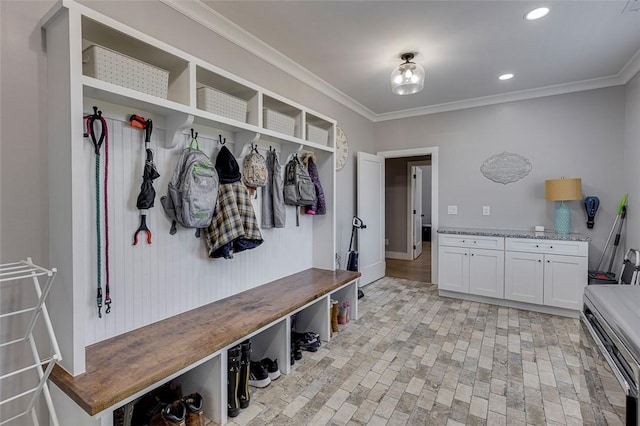 mudroom with ornamental molding, brick floor, and recessed lighting