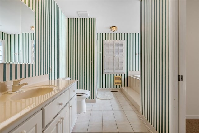 bathroom featuring tile patterned flooring, toilet, vanity, baseboards, and wallpapered walls