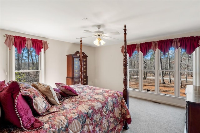 bedroom featuring carpet floors, multiple windows, visible vents, and a ceiling fan