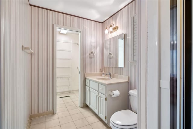 full bath featuring toilet, vanity, tile patterned flooring, baseboards, and wallpapered walls