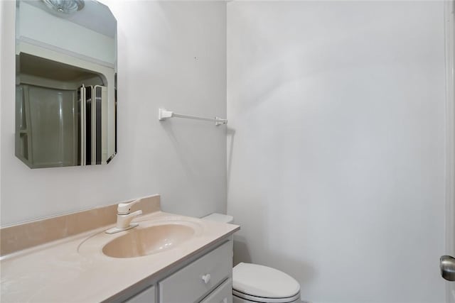 full bath with vanity, toilet, and walk in shower