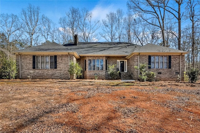 ranch-style house featuring crawl space, a chimney, and brick siding