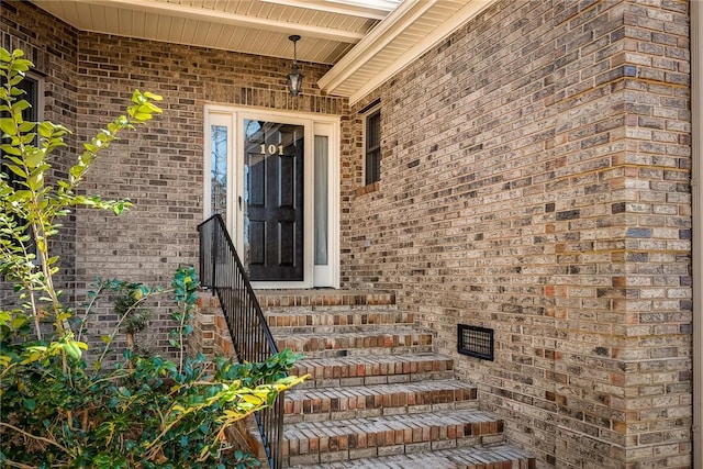 view of exterior entry featuring brick siding