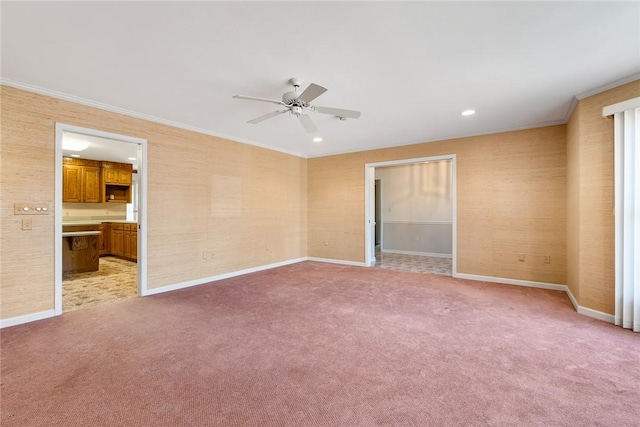 unfurnished room with a ceiling fan, baseboards, crown molding, and light colored carpet