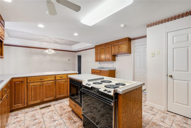 kitchen featuring decorative light fixtures, brown cabinets, light countertops, electric range, and black microwave