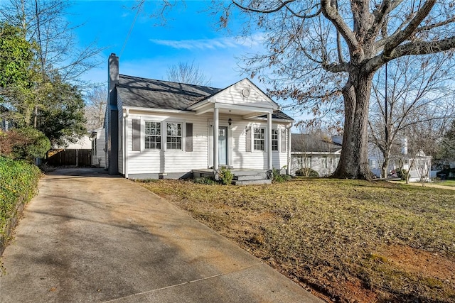 bungalow-style home with crawl space, a chimney, a front yard, and fence