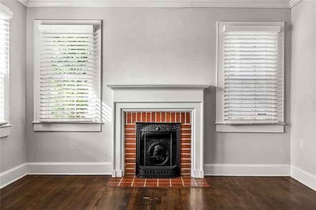 unfurnished living room featuring dark wood-style floors, a fireplace with flush hearth, baseboards, and crown molding