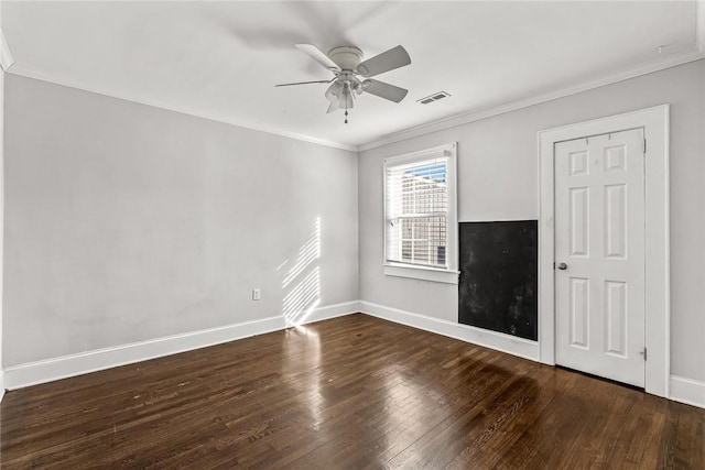 unfurnished room featuring baseboards, crown molding, visible vents, and dark wood-type flooring