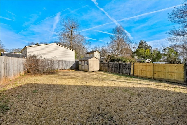 view of yard with a fenced backyard, an outdoor structure, and a shed