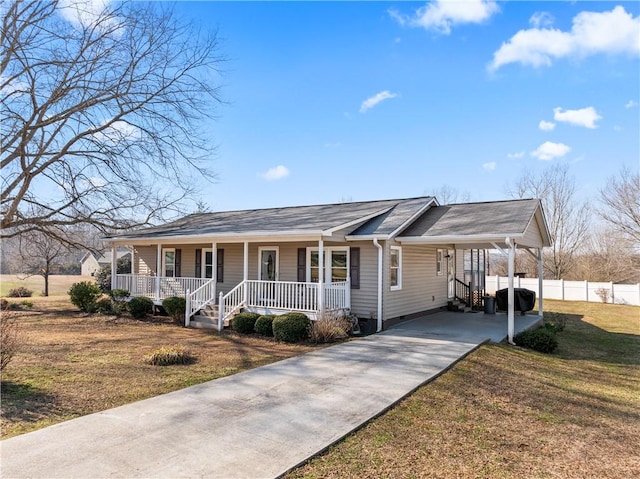 single story home featuring a porch, driveway, a carport, and a front lawn