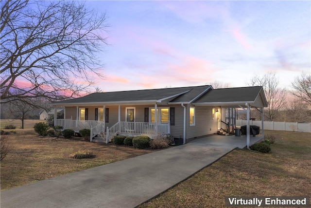 single story home with driveway, a lawn, a porch, and a carport