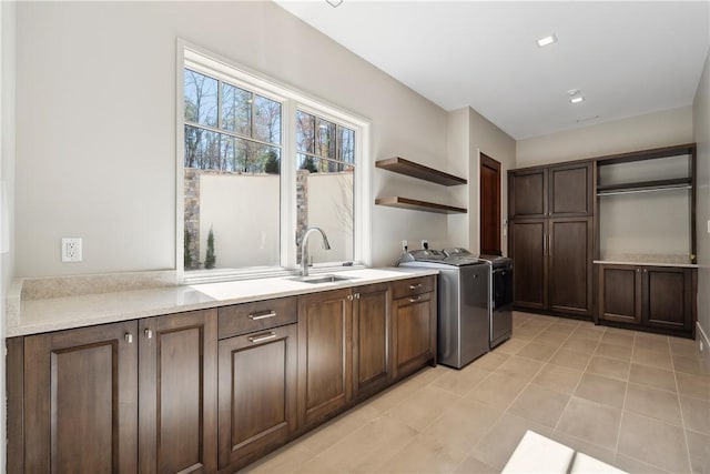 kitchen with a sink, open shelves, dark brown cabinets, and light countertops