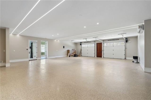 garage featuring baseboards and a wall mounted AC