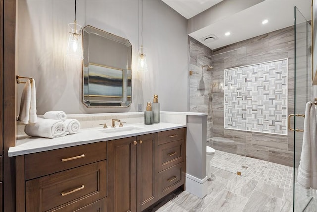 full bath featuring toilet, a stall shower, and vanity