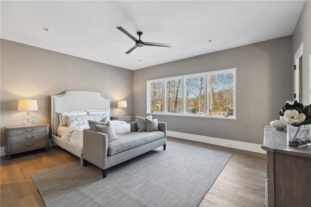 bedroom with ceiling fan, baseboards, and wood finished floors