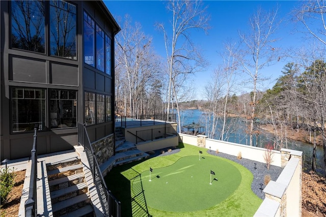 exterior space featuring stairs, a water view, and fence