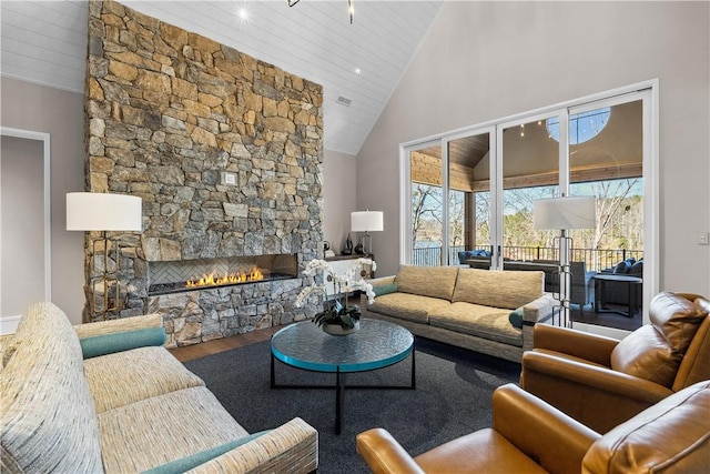 living room featuring high vaulted ceiling, a fireplace, and wood finished floors