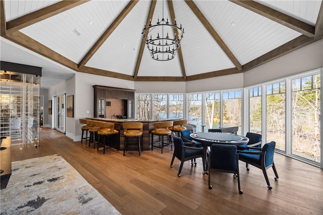 sunroom / solarium with vaulted ceiling with beams, wooden ceiling, and a notable chandelier