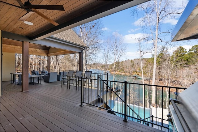 deck featuring a bar, a swimming pool, and a ceiling fan