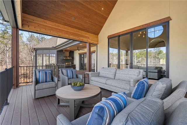 sunroom / solarium featuring vaulted ceiling, wooden ceiling, and a ceiling fan