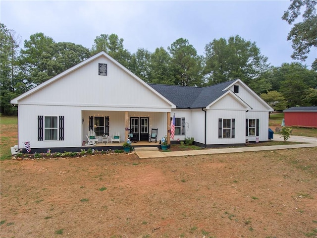 rear view of property featuring covered porch