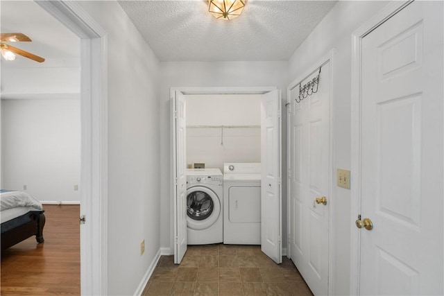 laundry area with a textured ceiling, laundry area, a ceiling fan, baseboards, and washer and dryer