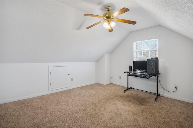 additional living space with a textured ceiling, vaulted ceiling, carpet, and baseboards