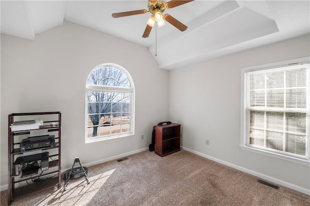 carpeted office with visible vents, vaulted ceiling, baseboards, and ceiling fan