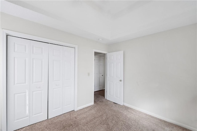 unfurnished bedroom featuring a closet, carpet, and baseboards