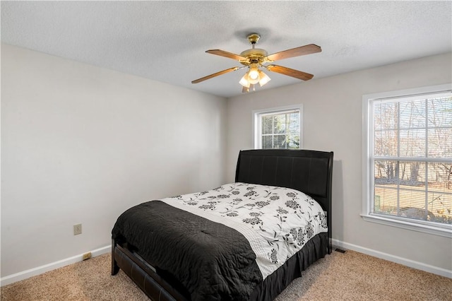 bedroom with multiple windows, light carpet, and baseboards