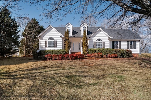 view of front facade with roof with shingles and a front yard