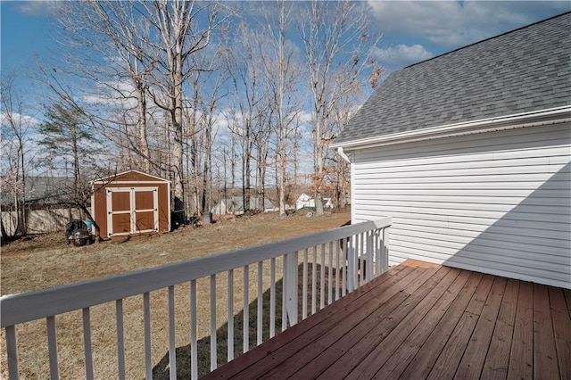 wooden terrace featuring an outbuilding, a yard, and a shed