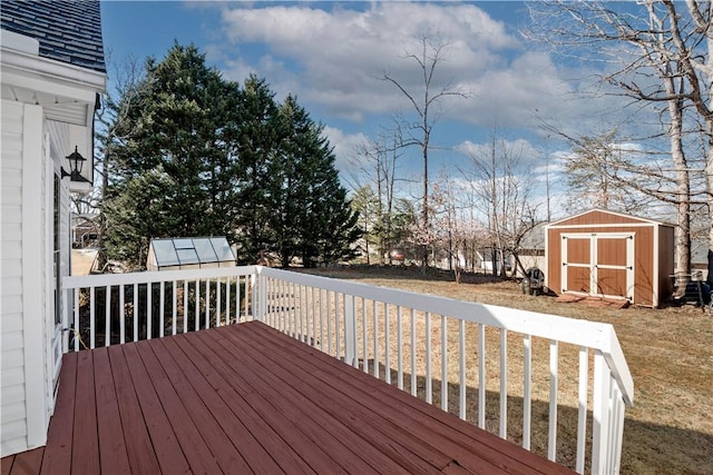 wooden deck with a yard, an outdoor structure, and a shed