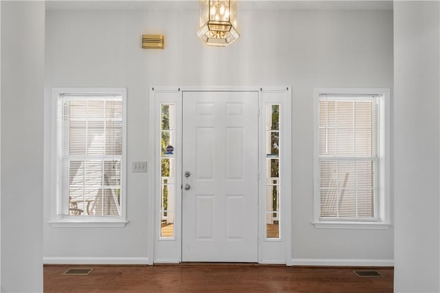 entryway with dark wood-style flooring, visible vents, and baseboards