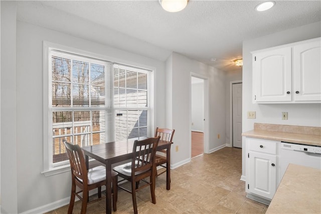 dining area featuring baseboards and a textured ceiling