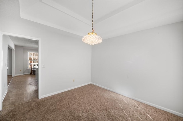 unfurnished room featuring carpet floors, baseboards, and a notable chandelier