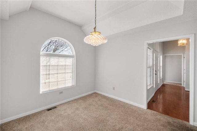 unfurnished room with carpet flooring, vaulted ceiling, visible vents, and baseboards