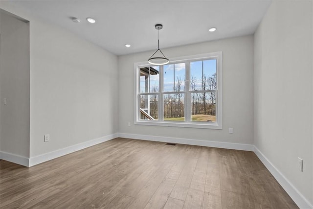 unfurnished dining area with recessed lighting, wood finished floors, visible vents, and baseboards