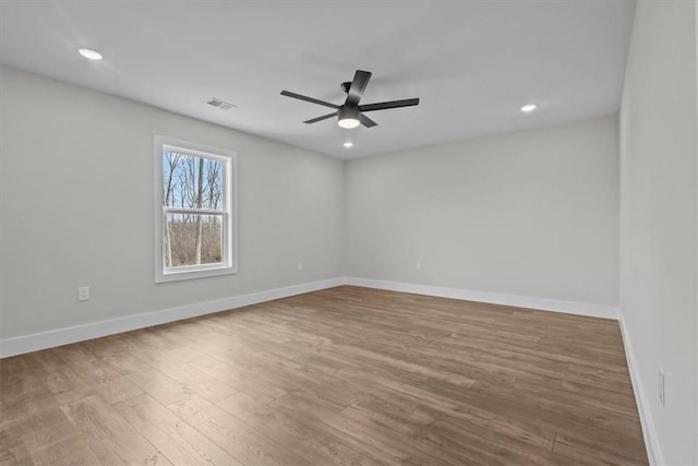 spare room with ceiling fan, recessed lighting, wood finished floors, and baseboards