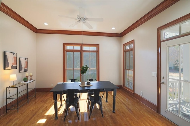 dining room featuring crown molding, baseboards, wood finished floors, and recessed lighting