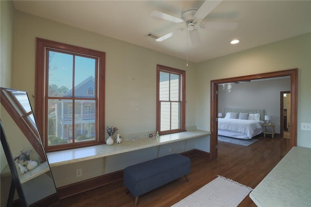 bedroom with dark wood-style floors, recessed lighting, visible vents, built in study area, and baseboards