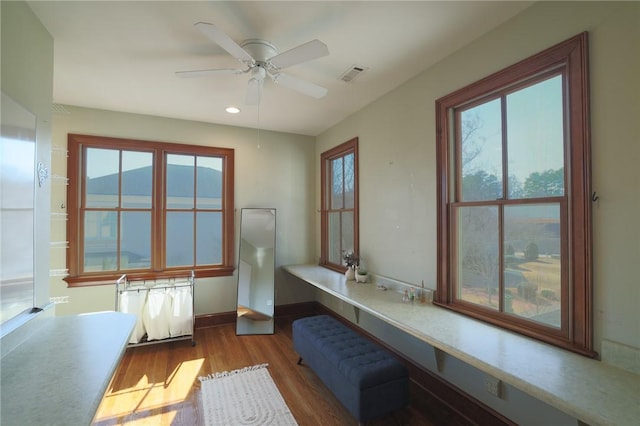 interior space with ceiling fan, visible vents, and radiator heating unit