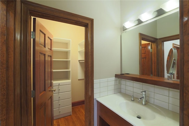 bathroom with wood finished floors, backsplash, and vanity