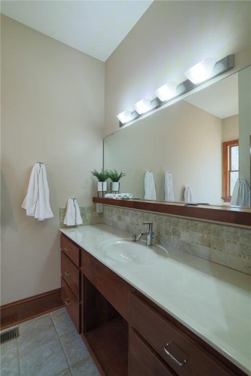 bathroom featuring visible vents, decorative backsplash, baseboards, tile patterned flooring, and vanity