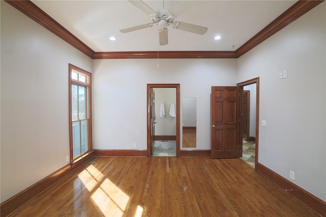 spare room featuring crown molding, recessed lighting, a ceiling fan, wood finished floors, and baseboards