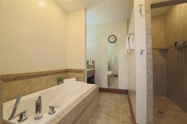 full bathroom with tile patterned flooring, vanity, baseboards, a bath, and walk in shower