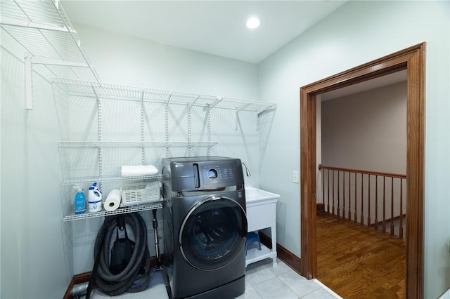 washroom featuring laundry area, tile patterned flooring, washing machine and clothes dryer, and baseboards