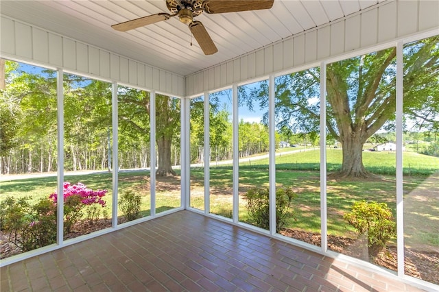 unfurnished sunroom featuring a ceiling fan